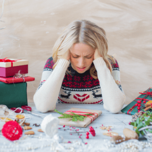woman wrapping holiday gifts looking stressed