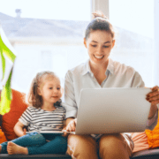mom with young daughter researching on laptop