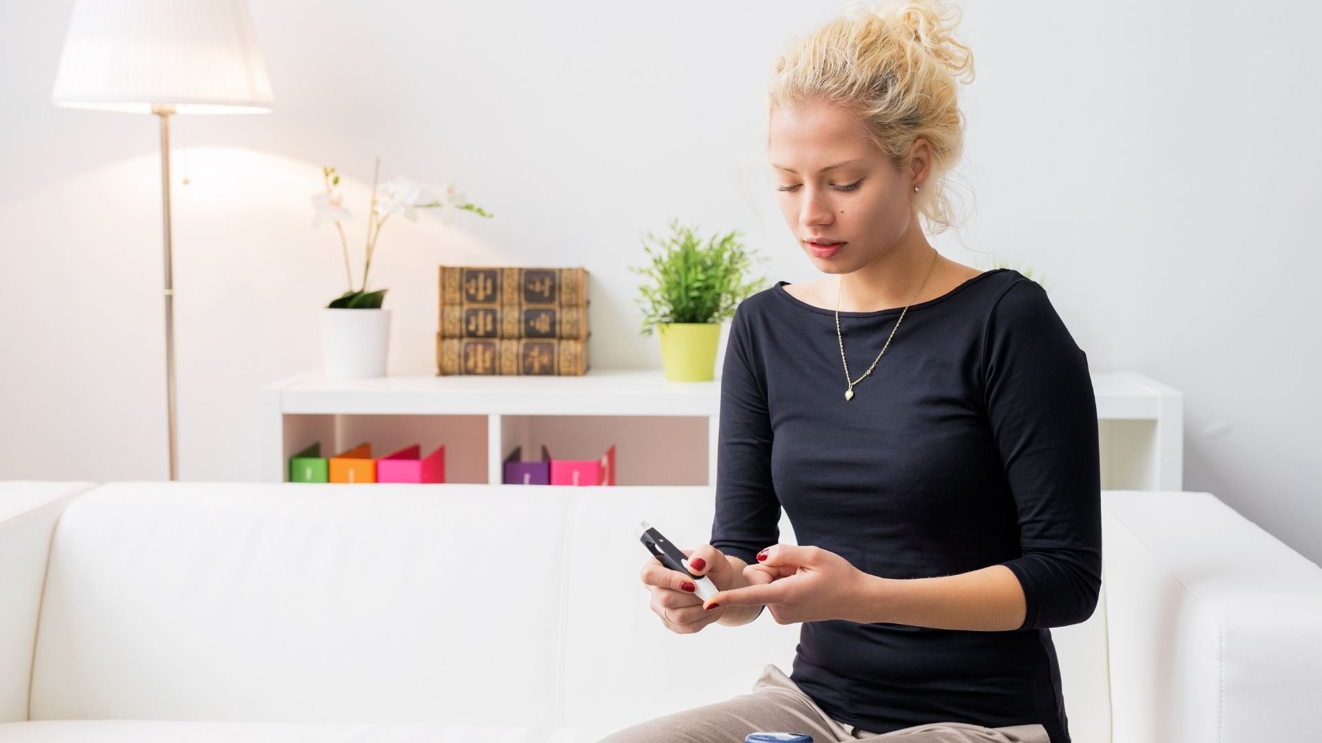 young woman checking blood sugar - diabetes article