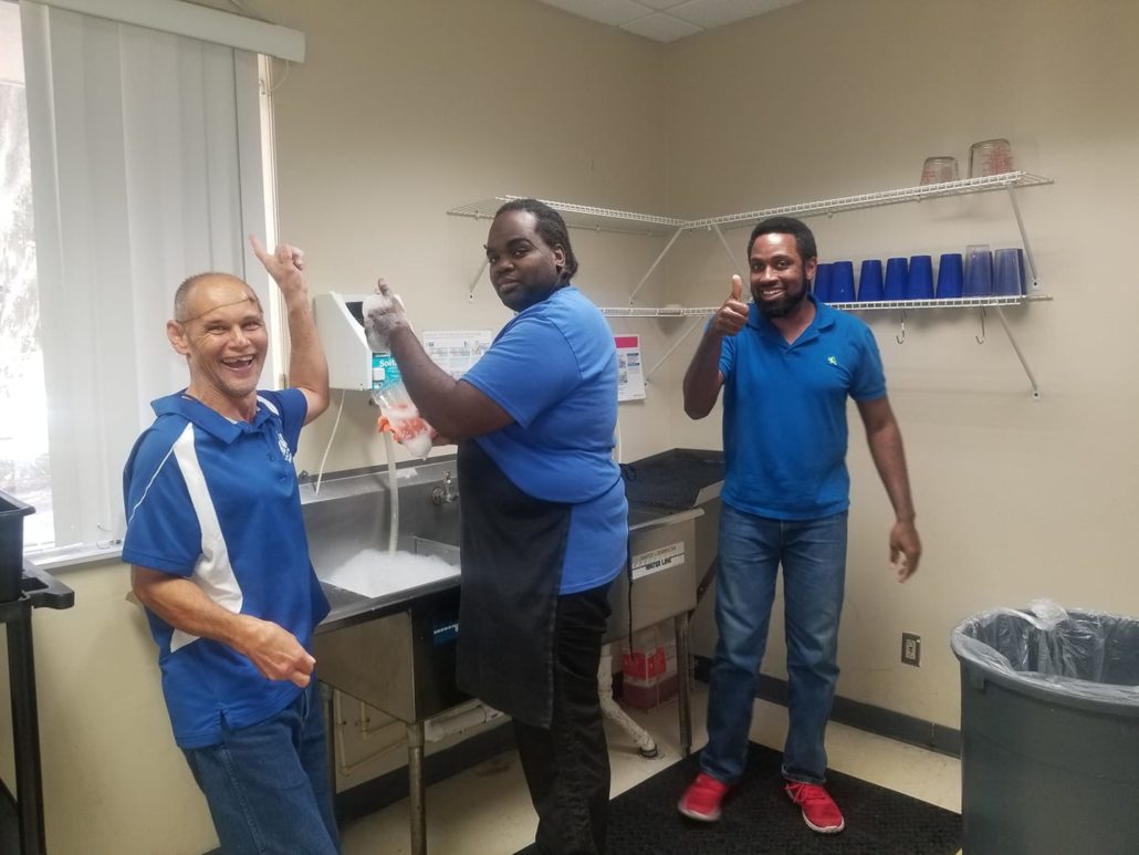 clubhouse members washing dishes and smiling at camera