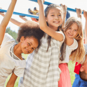 group of smiling children on monkey bars