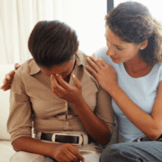 woman comforting another woman