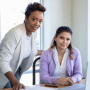 two professional women smiling at camera