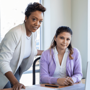 two professional women smiling at camera