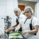 two people cooking in industrial kitchen