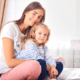 Mom and Child sitting on bed stock file