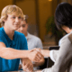 young blonde man shaking hand of HR professional stock photo