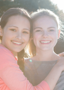 two young females one side hugging other