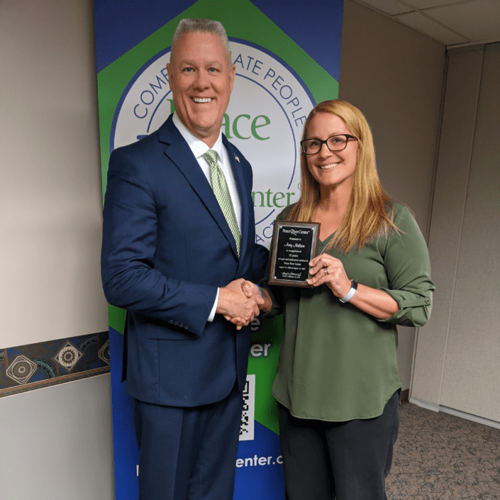 CEO Larry Williams and Amy Nelson with work anniversary plaque