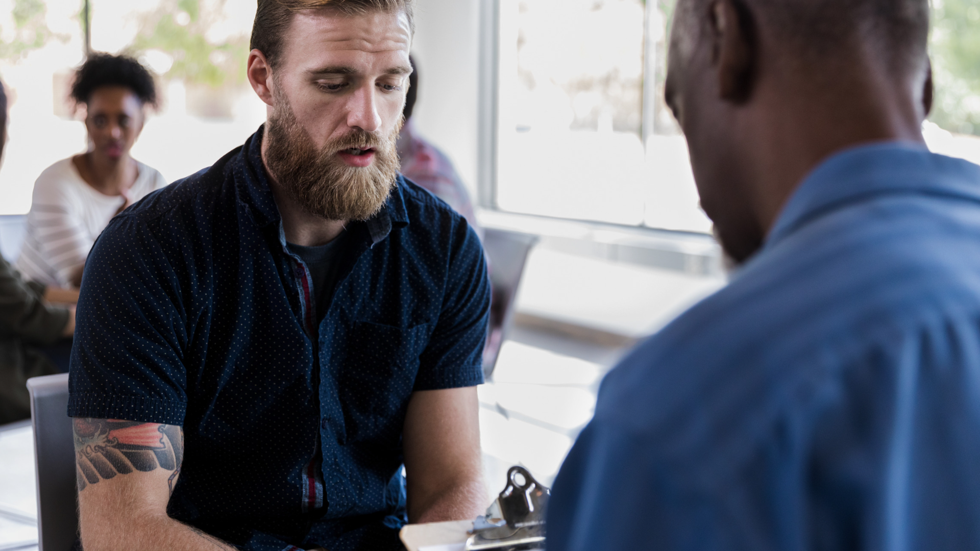 man talking to another man about health care needs