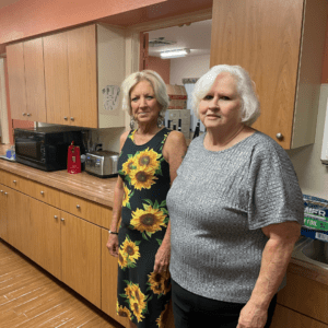 Group home client and staff member posing by new cabinets made possible thanks to the Kathleen Roehm Memorial Fund.