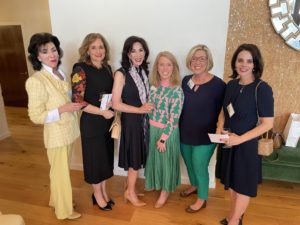 Six women are posing for a group photo at a fundraising event.