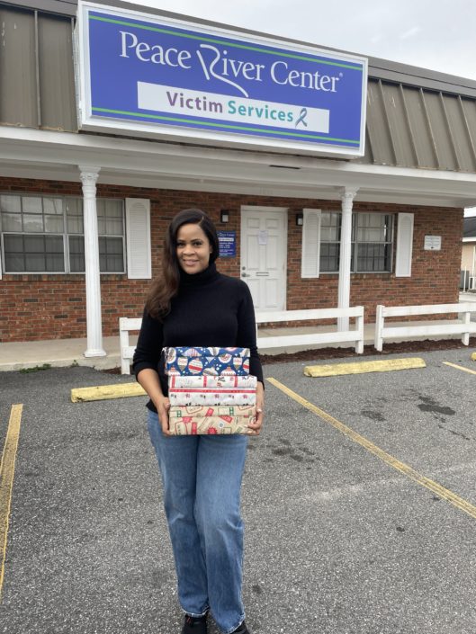 One woman carrying wrapped Christmas gifts