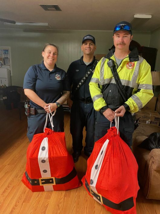Three fire fighters with Santa sacks