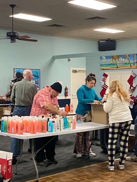 Four people unboxing shampoos and conditioners